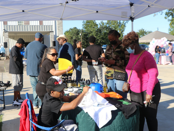 Outdoor event scene with vendors selling handmade goods and shoppers engaging in a vibrant, community setting.